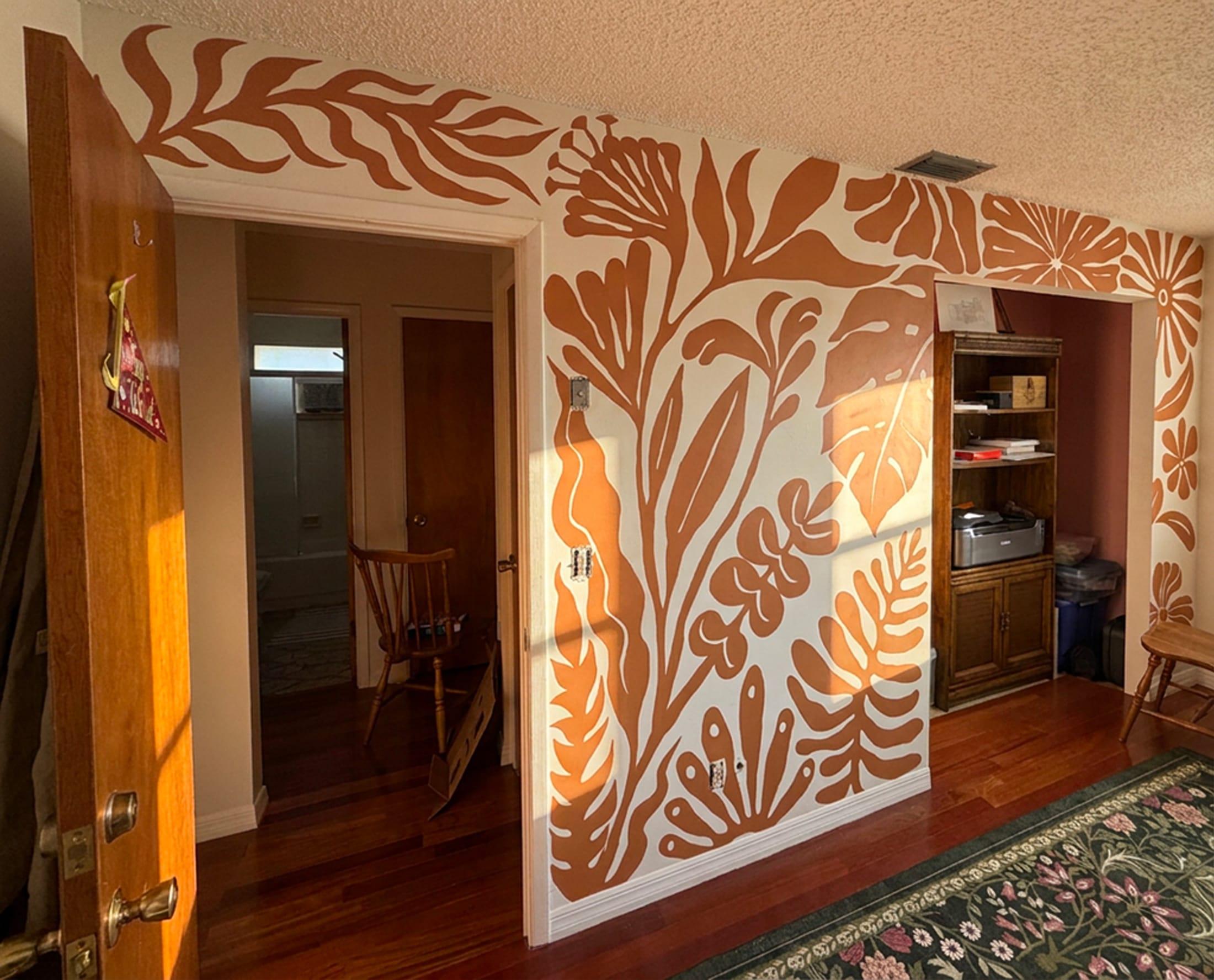 Terracotta botanical pattern mural wrapping the walls of a home interior